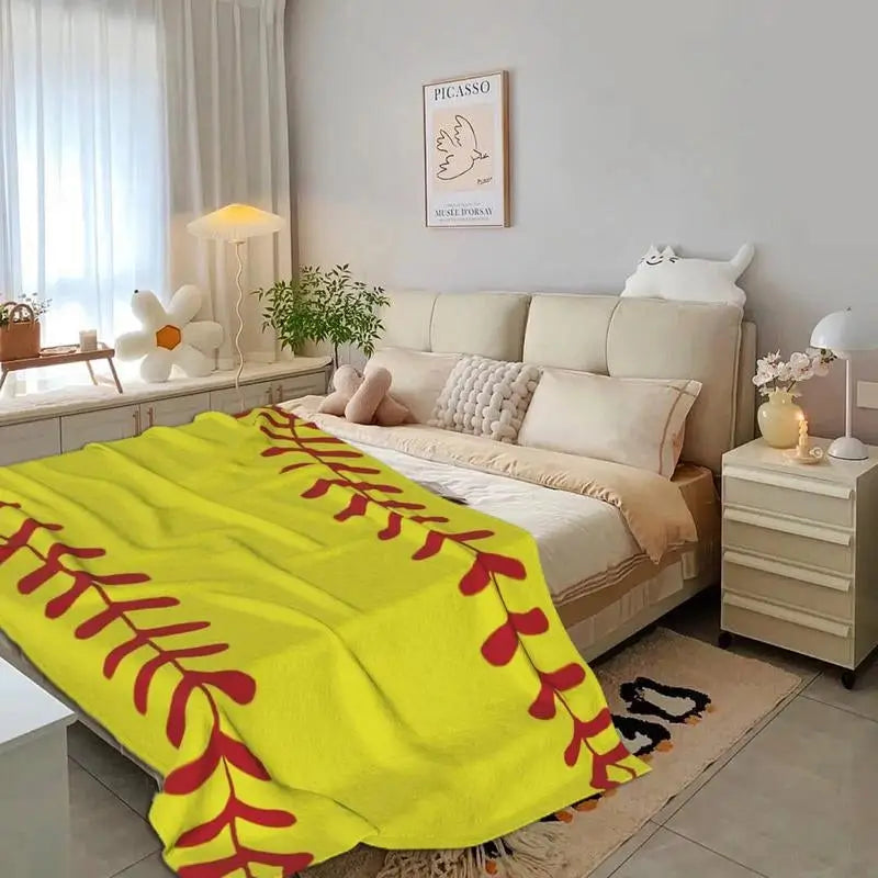a bedroom with a couch and a baseball blanket