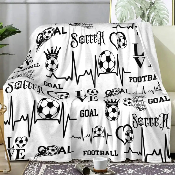 a white blanket with soccer symbols on it
