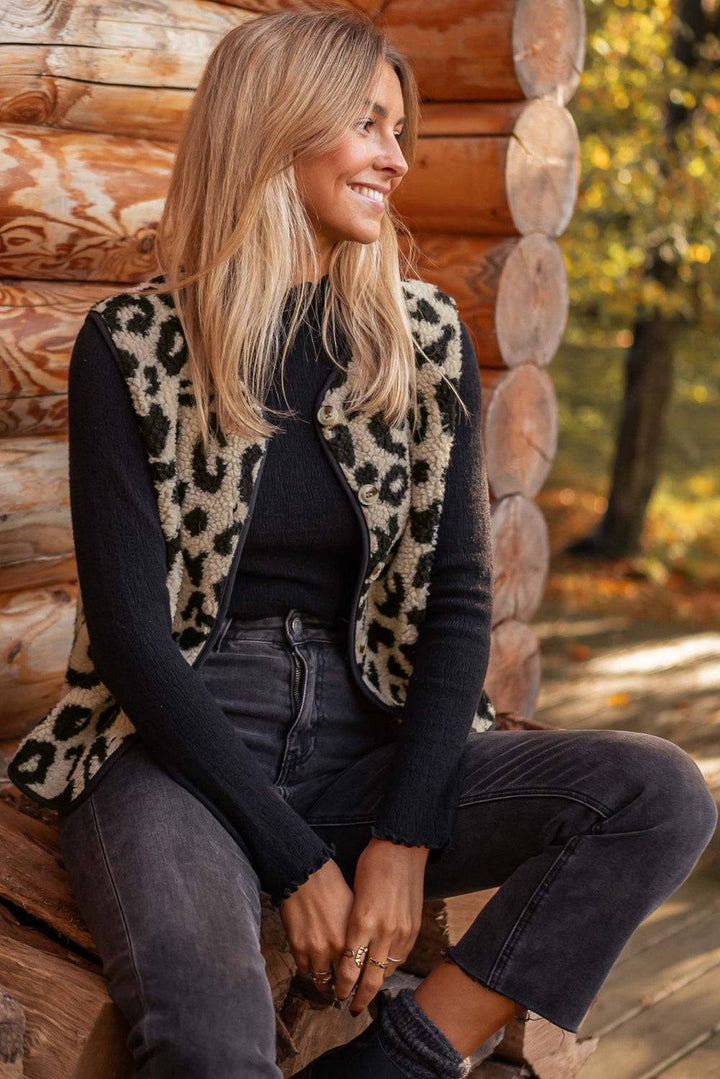 a woman sitting on a log in front of a log cabin