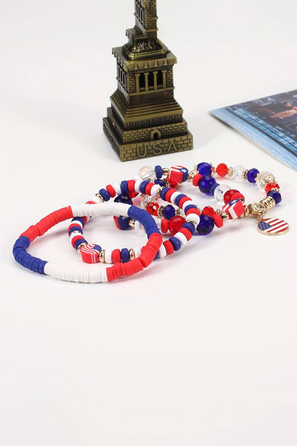 a stack of bracelets with a statue of liberty in the background