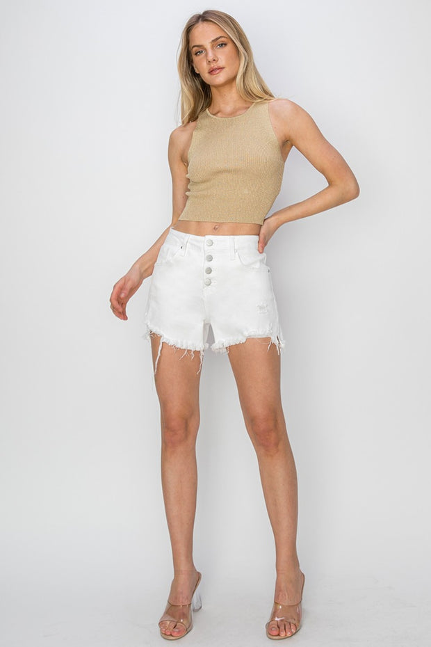 a woman wearing a tan top and white shorts