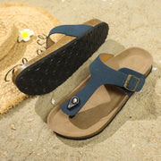 a pair of sandals sitting on top of a sandy beach