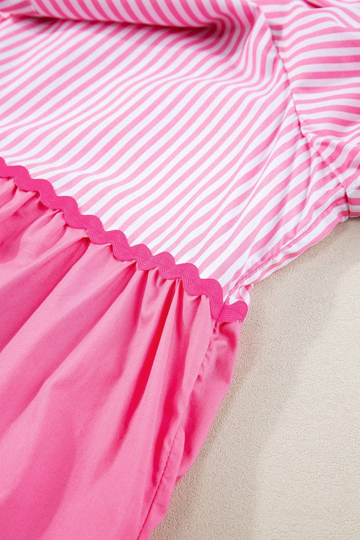 a pink and white striped dress laying on a bed