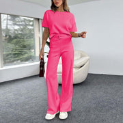a woman in a pink jumpsuit standing in a room