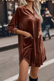 a blonde woman wearing a brown velvet dress and thigh high boots
