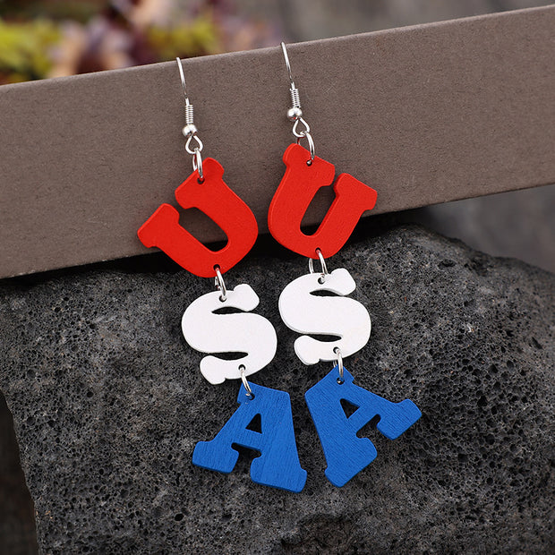 a pair of red, white, and blue acrylic earrings on a rock