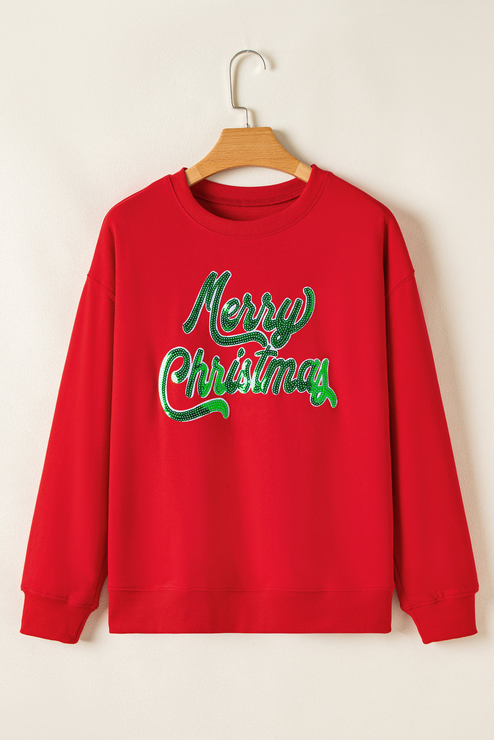 Front view of Red Merry Christmas Crewneck Drop Shoulder Loose Sweatshirt on hanger, featuring bold green letter print, shop now at Faith & Co. Boutique.