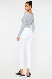 a woman in a grey sweater and white pants