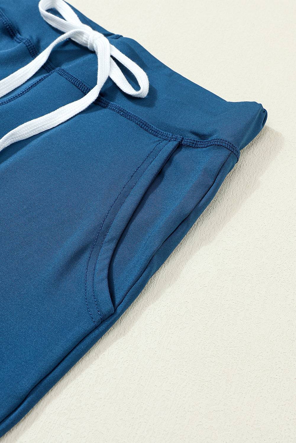 a close up of a blue sweat pants with white drawstrings