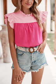 a woman wearing a pink top and denim shorts