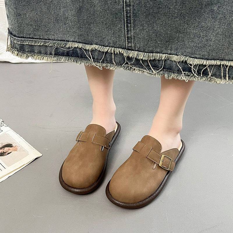 a person wearing brown shoes standing next to a newspaper