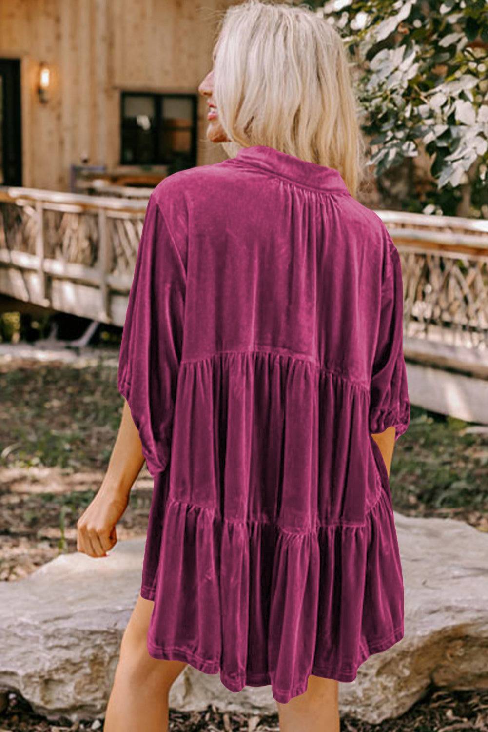 a woman in a purple dress walking towards a house