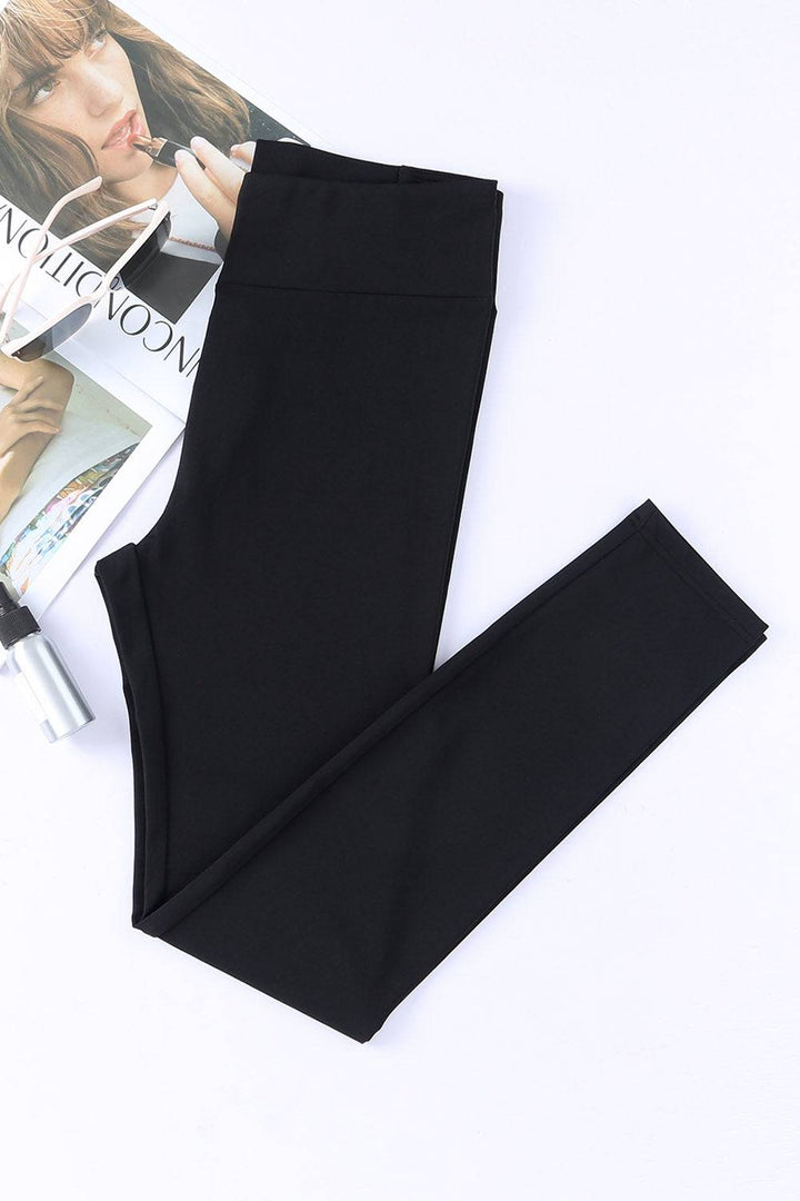 a pair of black leggings sitting on top of a magazine