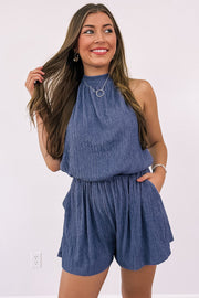 a woman in a blue romper posing for a picture