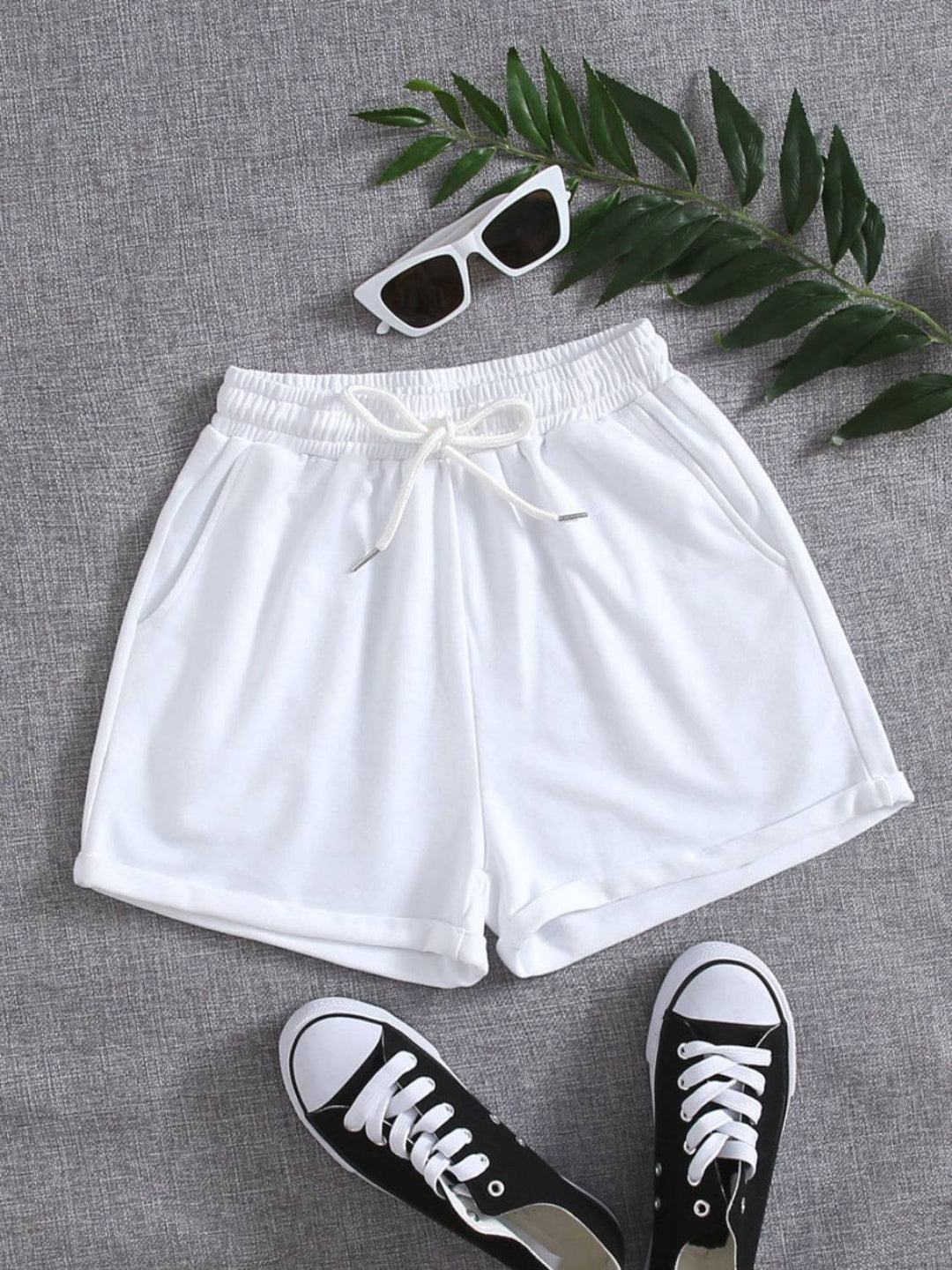 a pair of white shorts and a pair of sunglasses