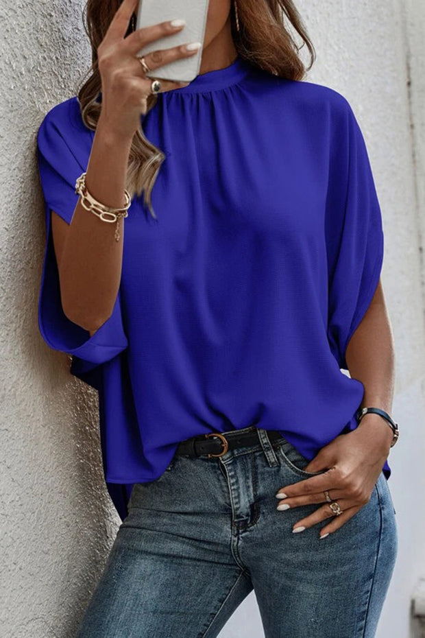 a woman wearing a blue blouse holding a cell phone