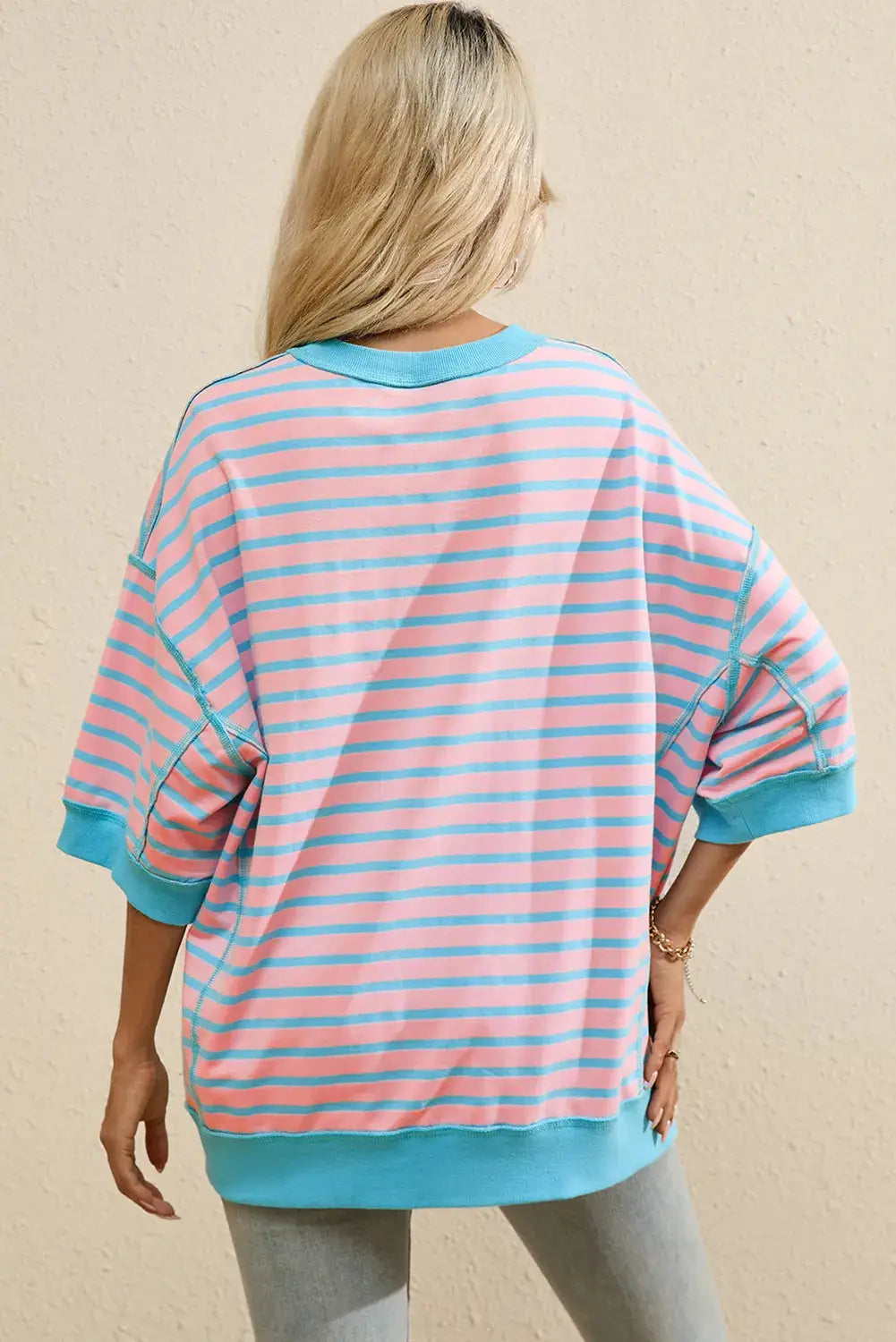 a woman wearing a pink and blue striped top