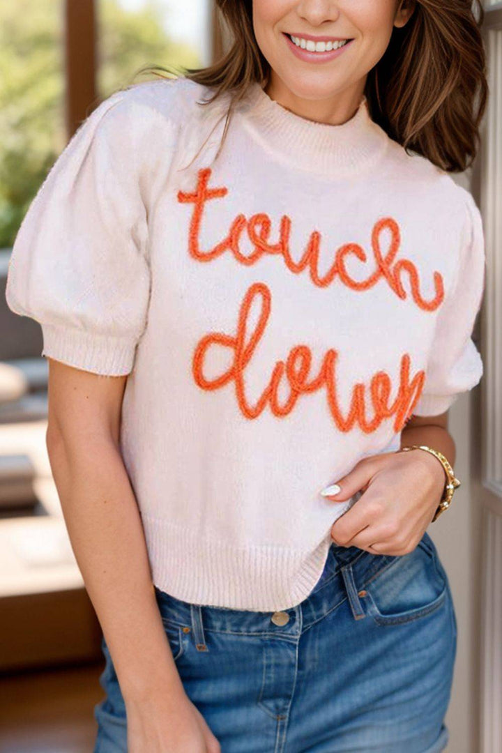 a woman wearing a sweater that says touch down