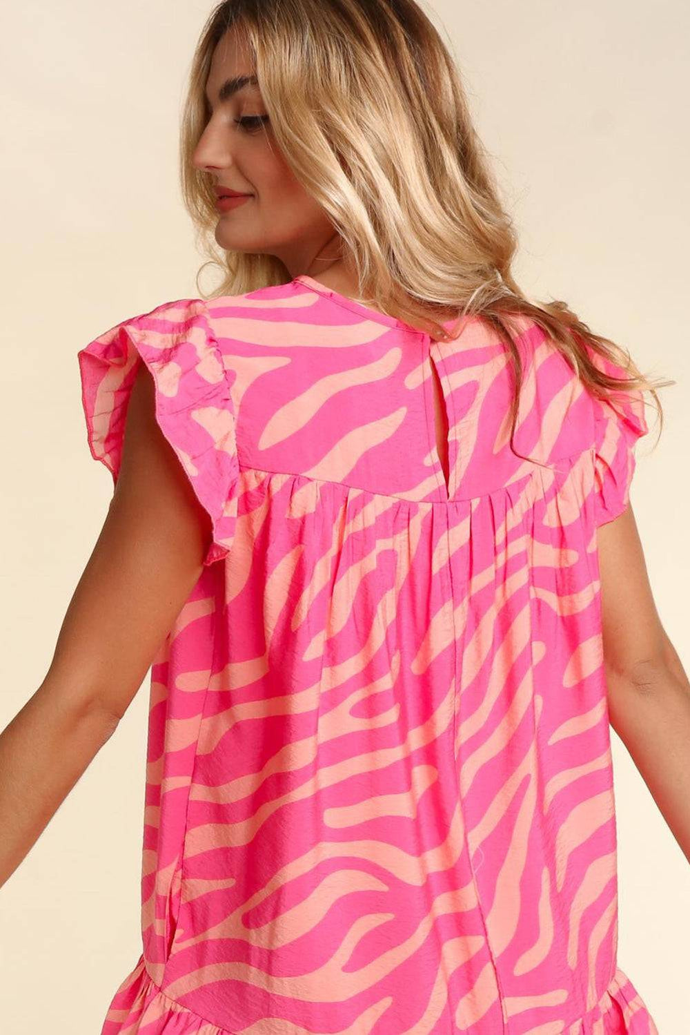 a woman wearing a pink zebra print top