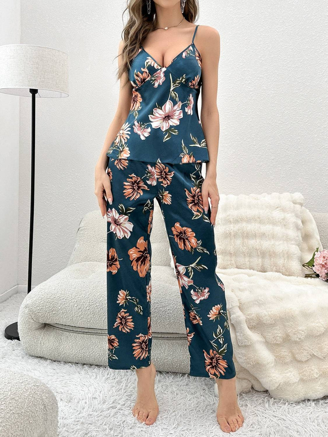 a woman standing in a room wearing a floral jumpsuit