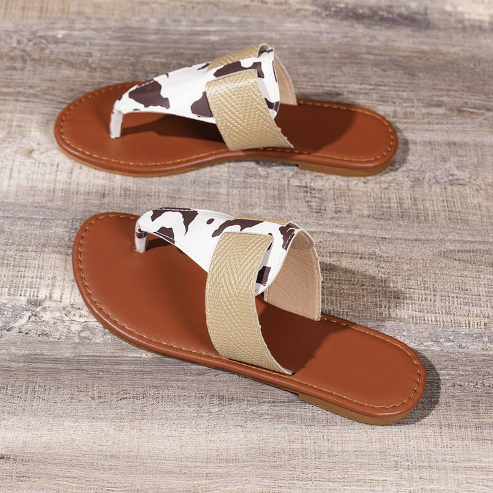 a pair of brown and white sandals on a wooden floor