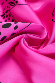 a close up of a pink fabric with black dots