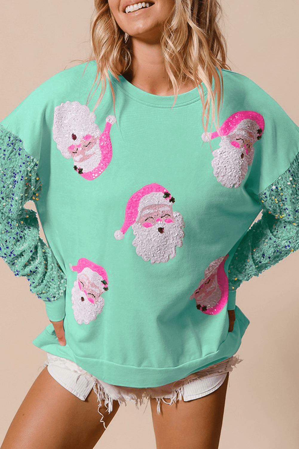 Mint green Moonlight Jade Christmas sweatshirt with sequin Santa faces and sparkly green sleeves, available at Faith & Co. Boutique.
