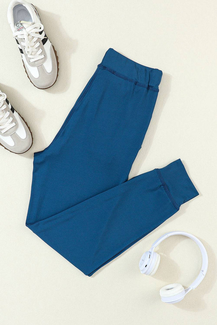 a pair of blue pants and headphones on a white surface