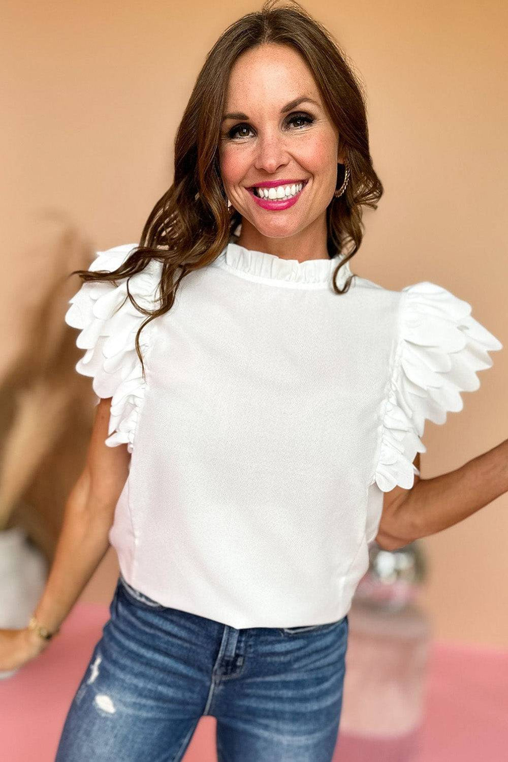 a woman in jeans and a white top posing for a picture