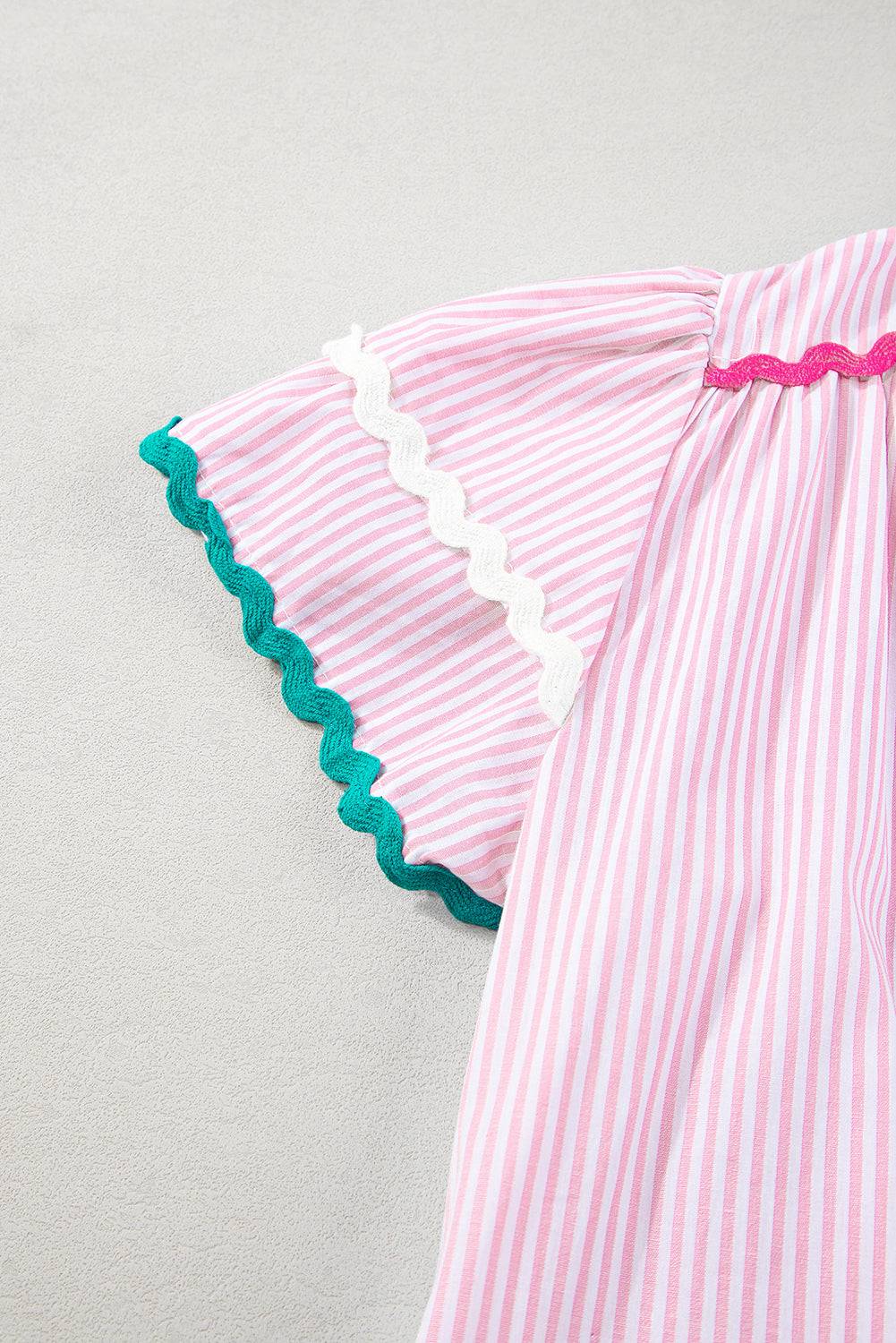 a pink and white striped dress with blue trim