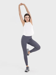 a woman in a white top is doing a yoga pose