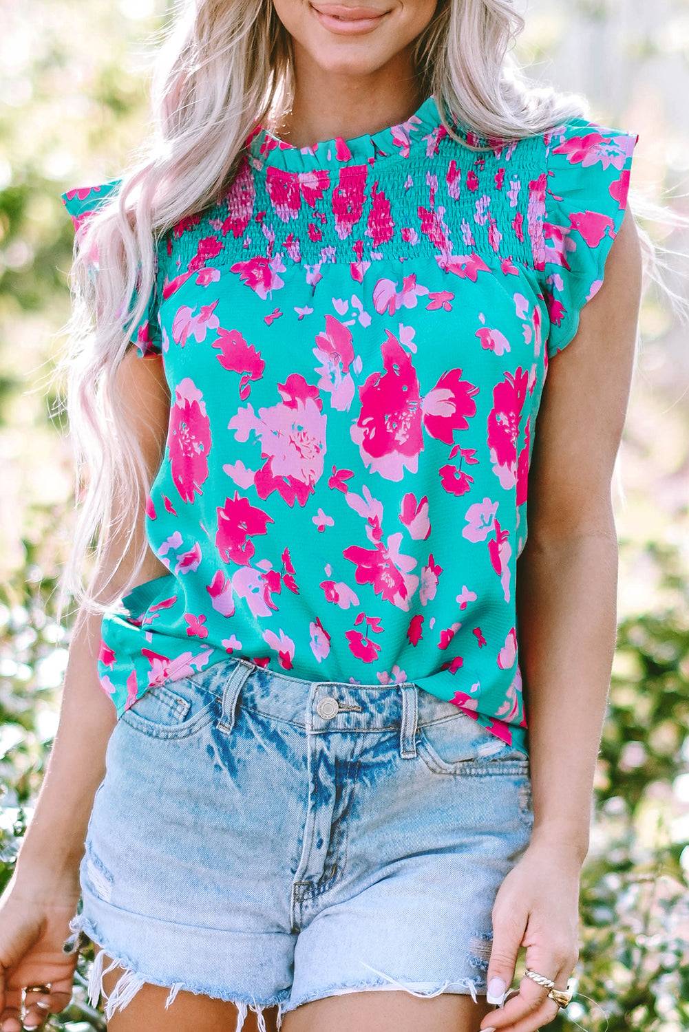 a woman with blonde hair wearing a floral top
