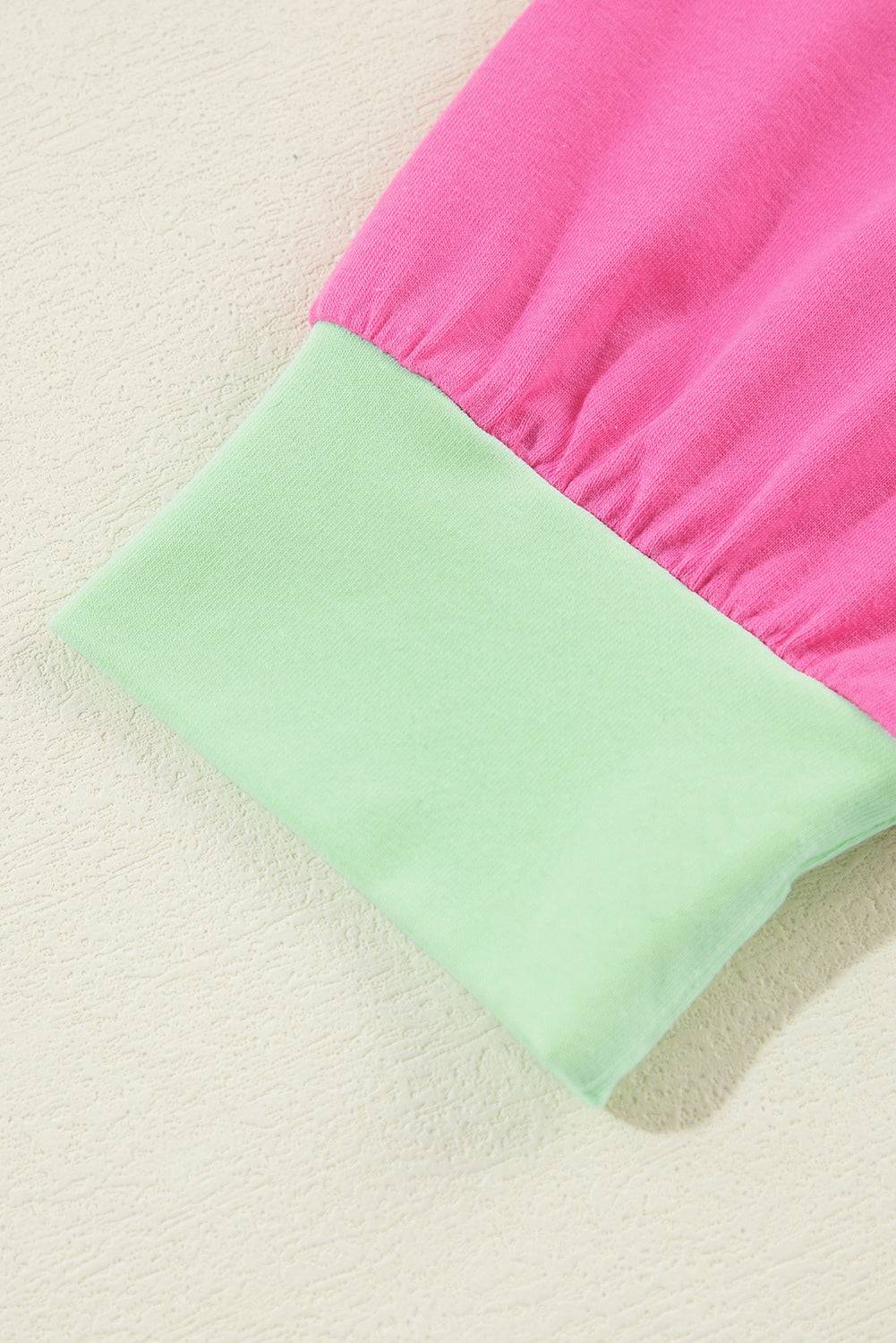 a close up of a pink and green pillow