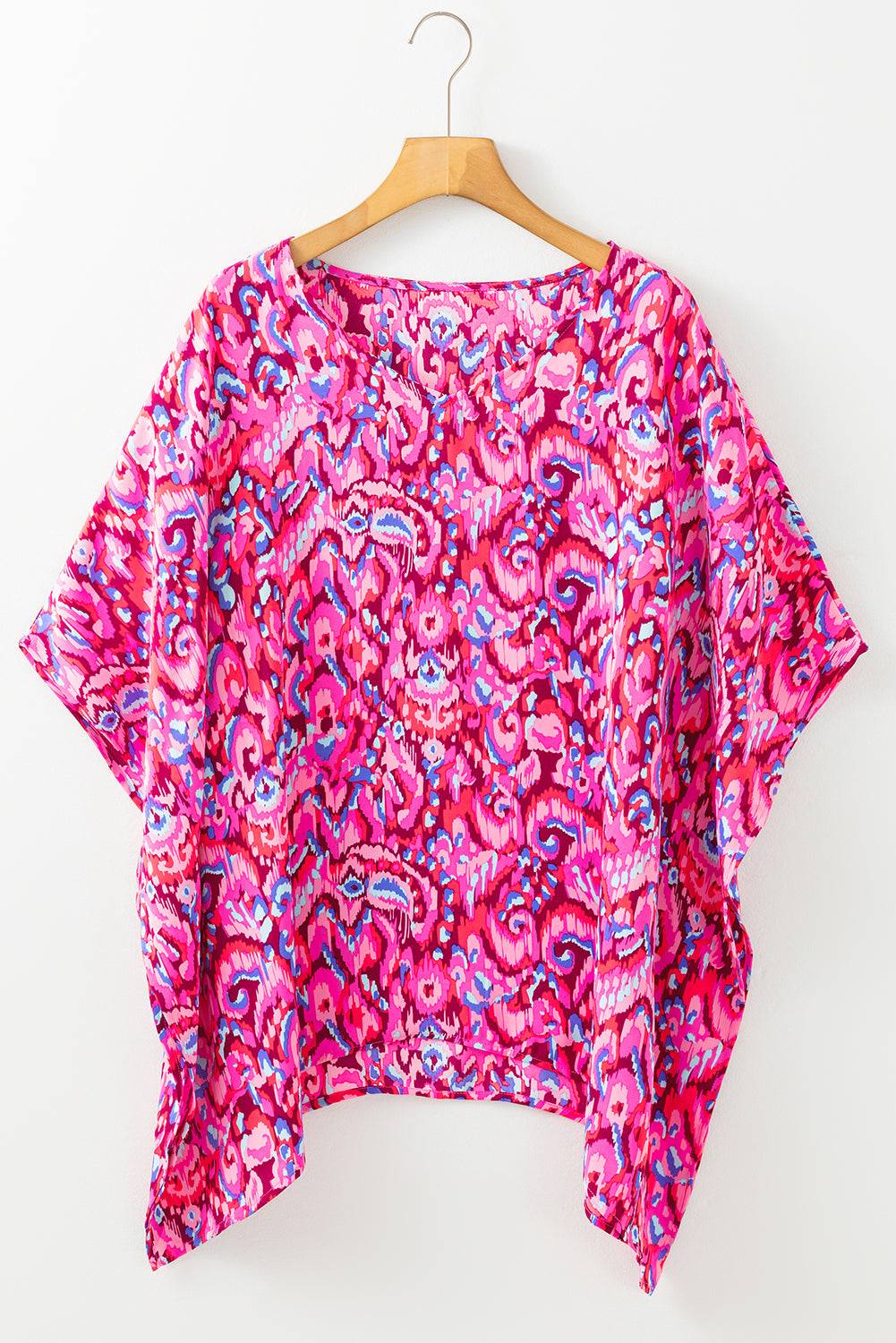 Flat lay of Pink Abstract Print V Neck Half Sleeve Loose Fit Tunic Blouse on hanger, showcasing bold abstract pattern and flowy silhouette.