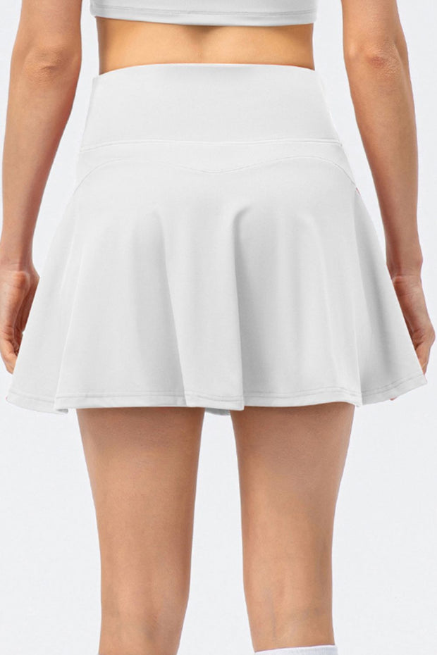 a woman wearing a white tennis skirt