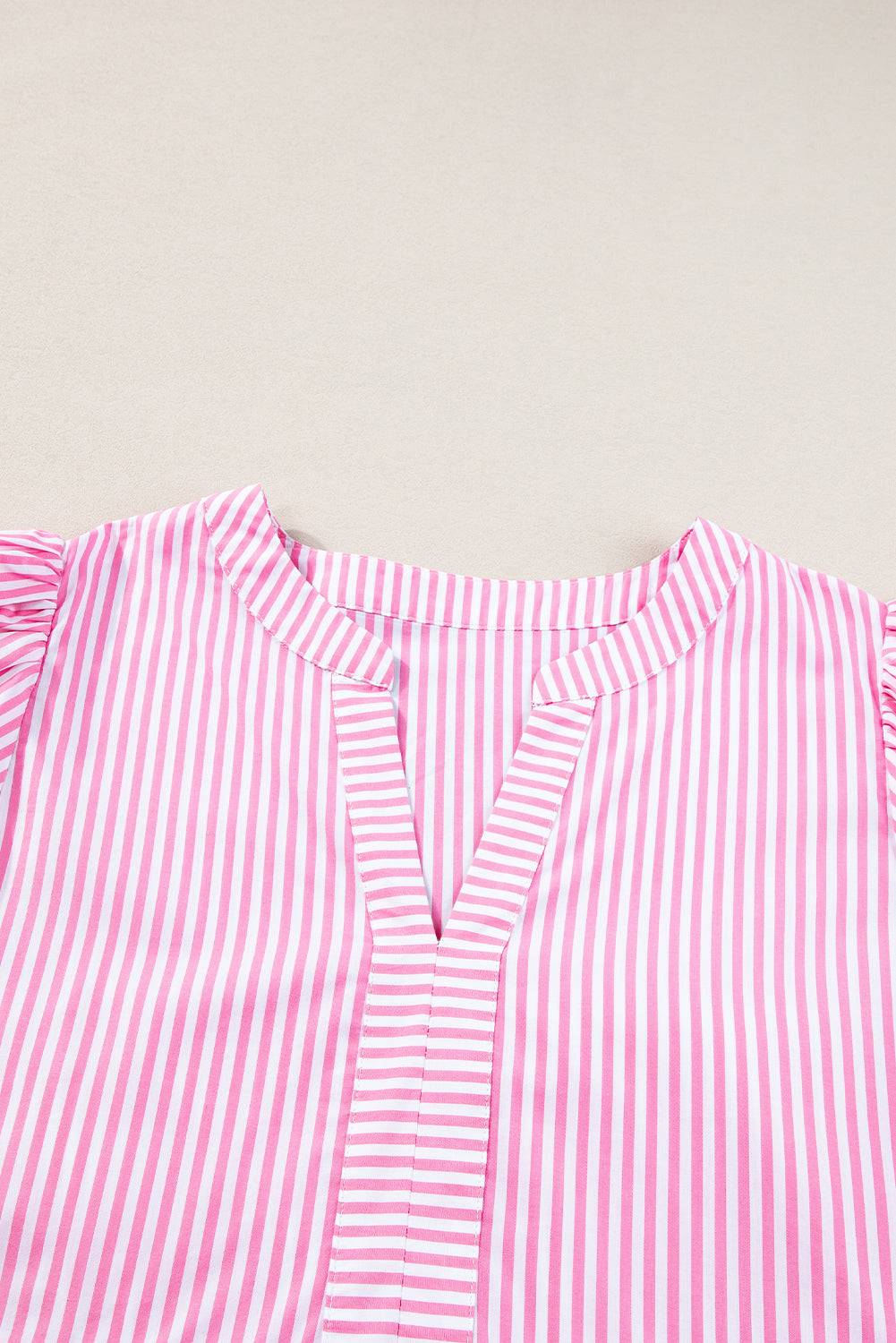 a pink and white striped shirt laying on top of a table