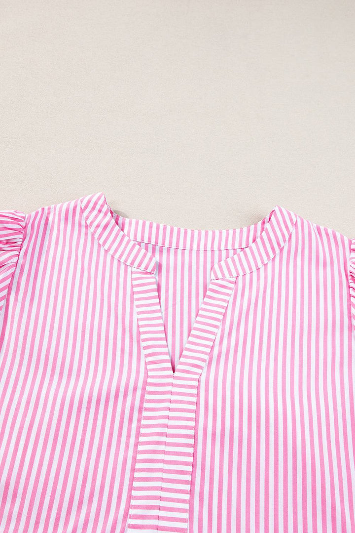 a pink and white striped shirt laying on top of a table