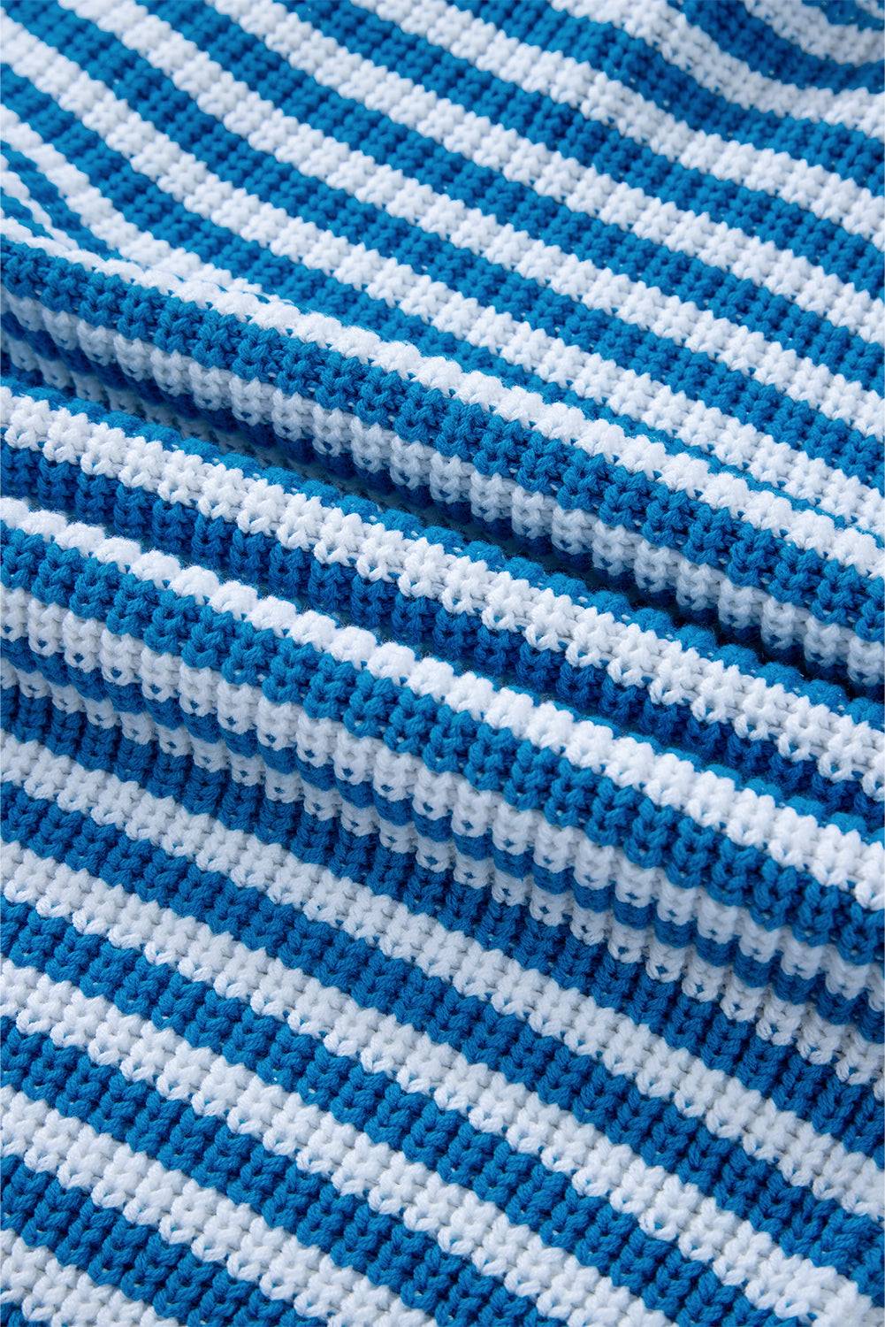 a close up of a blue and white knitted blanket