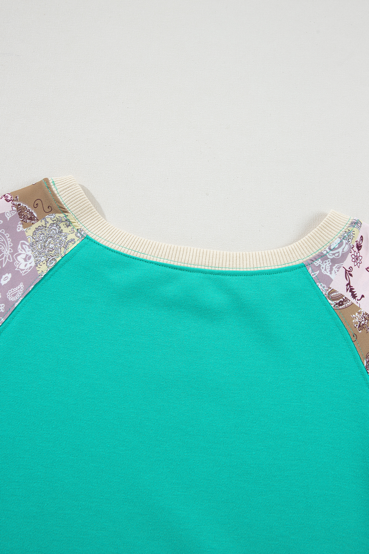 Close-up of neckline on Aruba Blue Plaid Vintage Paisley Patchwork Long Sleeve Raglan Top with ribbed trim. Shop at Faith & Co. Boutique.