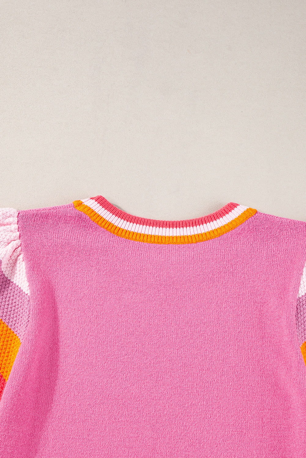 a pink sweater with orange, white, and pink stripes