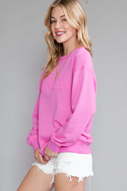 a woman wearing a pink sweater and white shorts