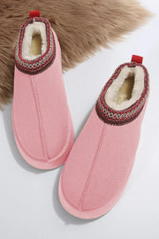 a pair of pink slippers sitting on top of a fur rug