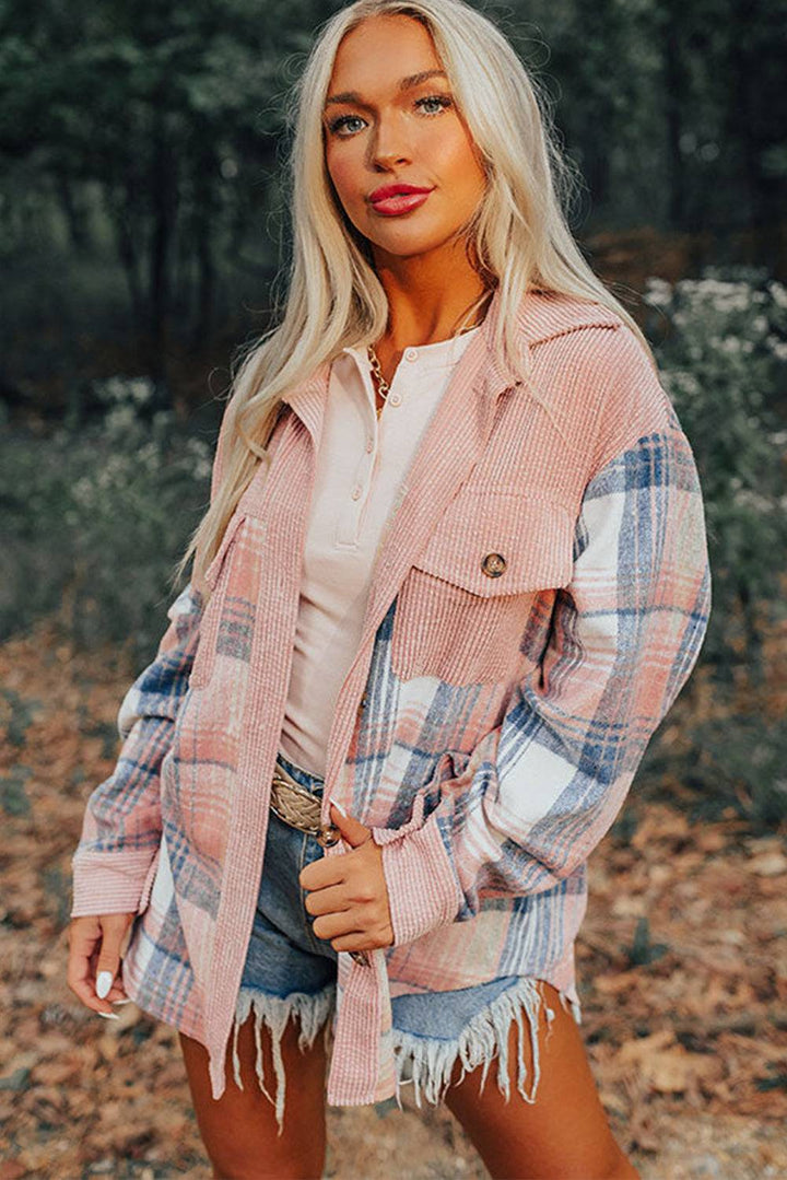 a woman standing in the woods wearing a pink jacket