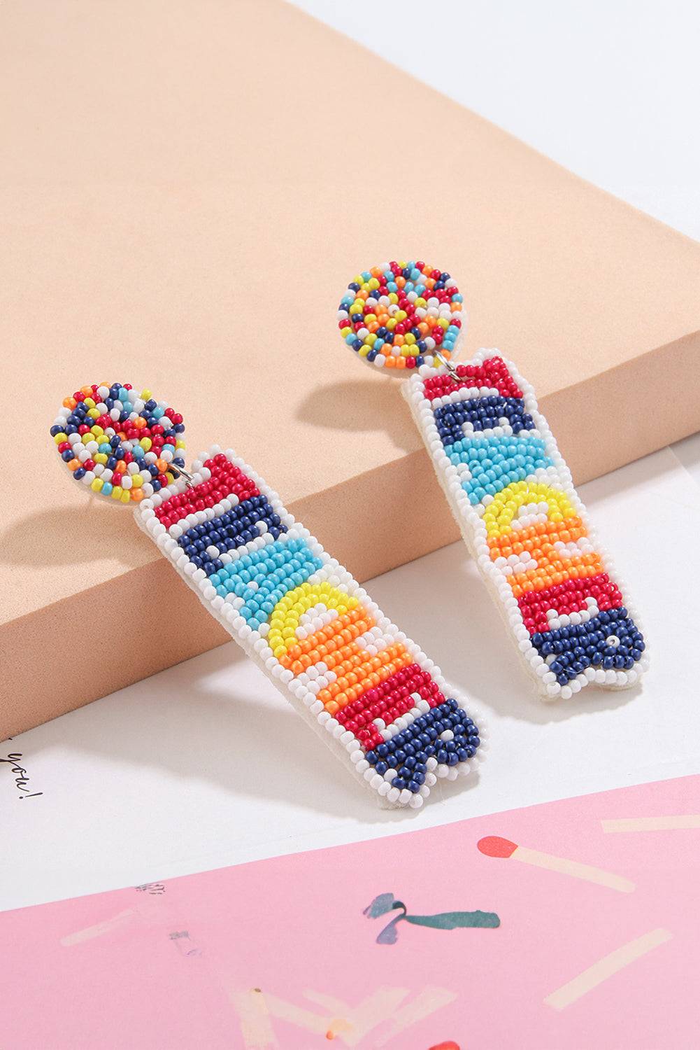 a pair of colorful beaded earrings sitting on top of a table