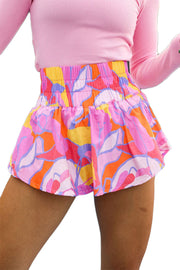 a woman in a pink shirt and colorful skirt