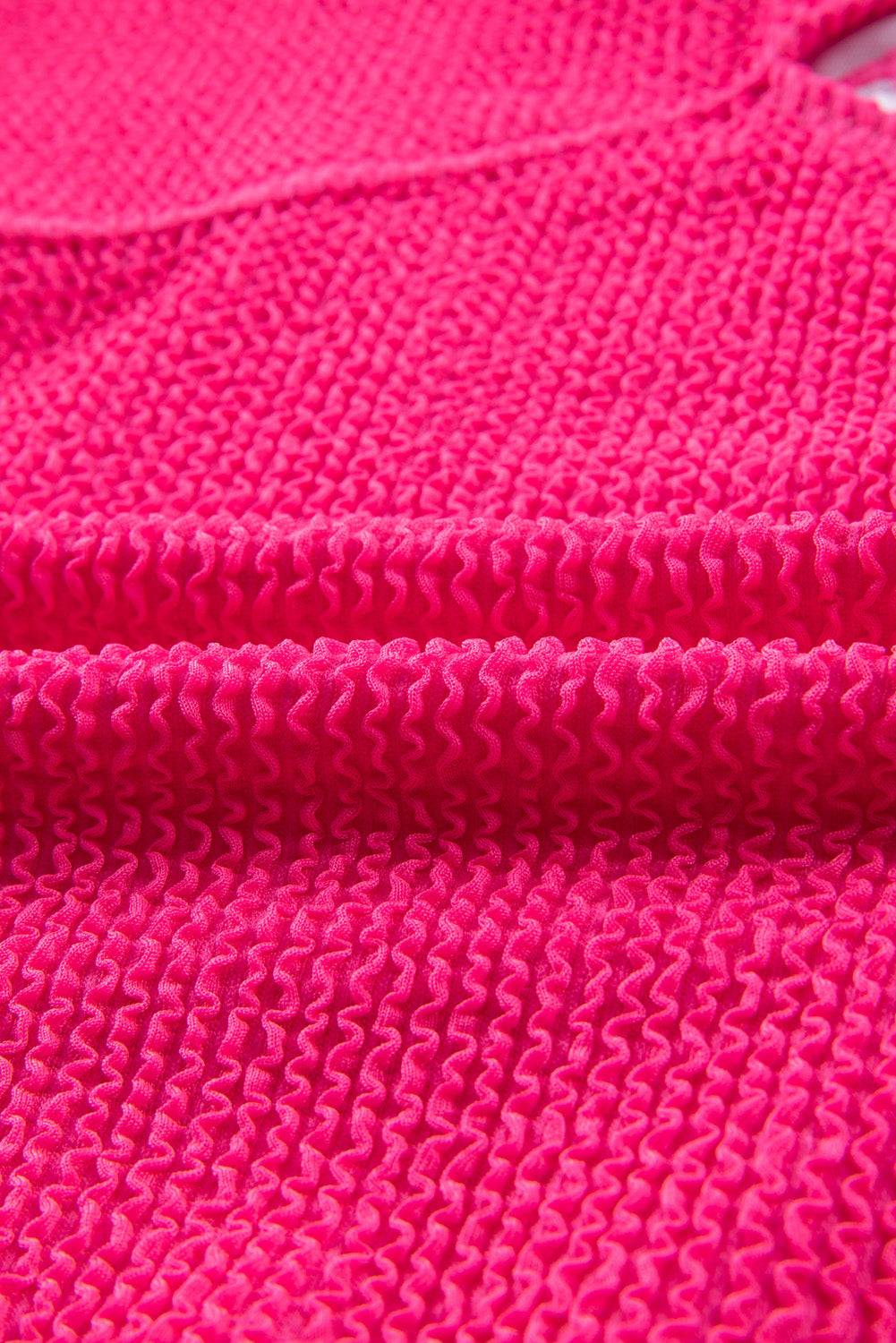 a bright pink knitted blanket with a white background