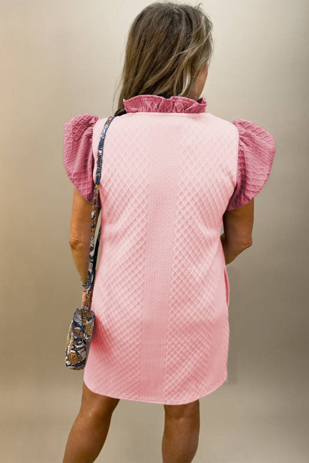 a woman in a pink dress is holding a purse