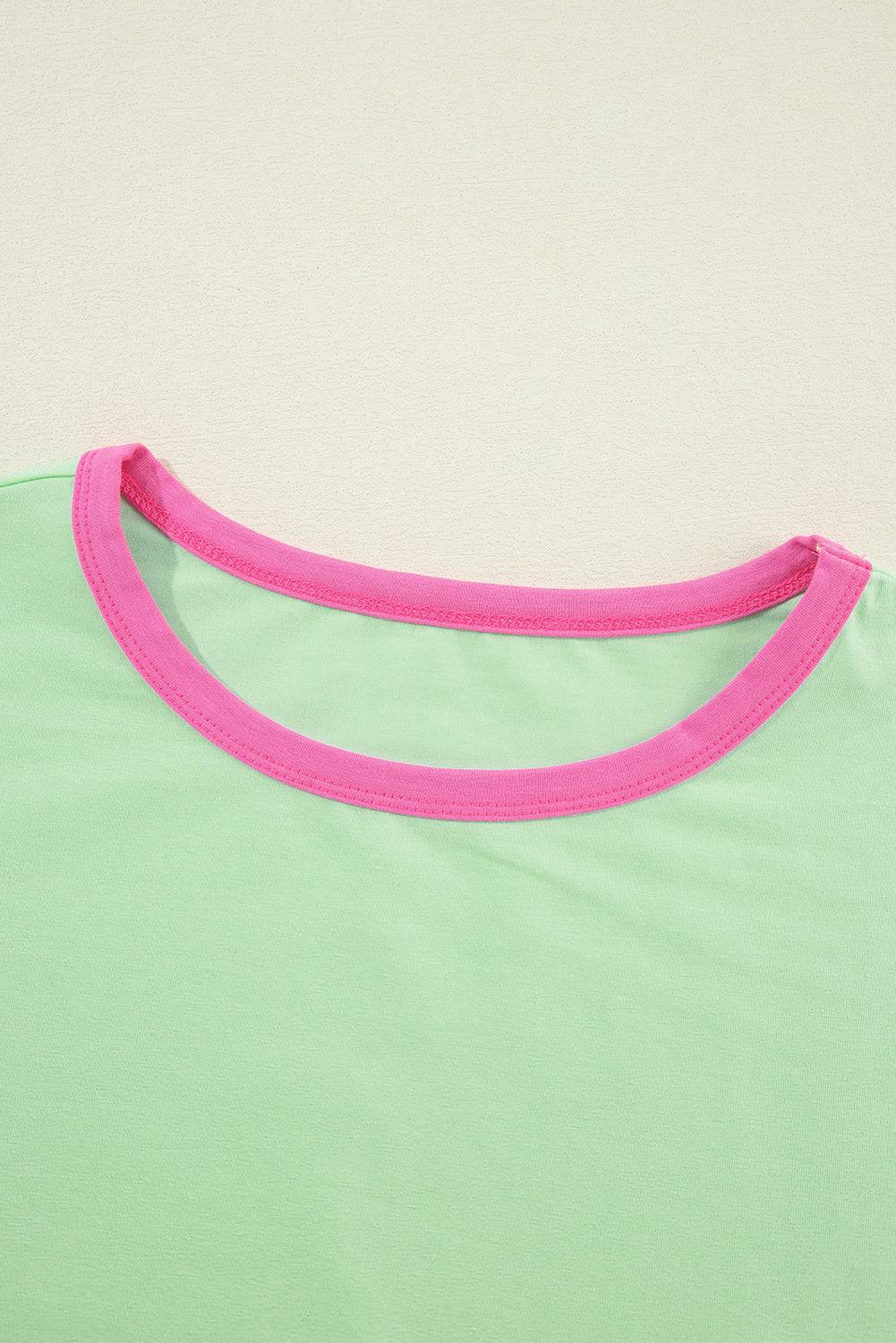 a woman's green and pink shirt laying on a white surface