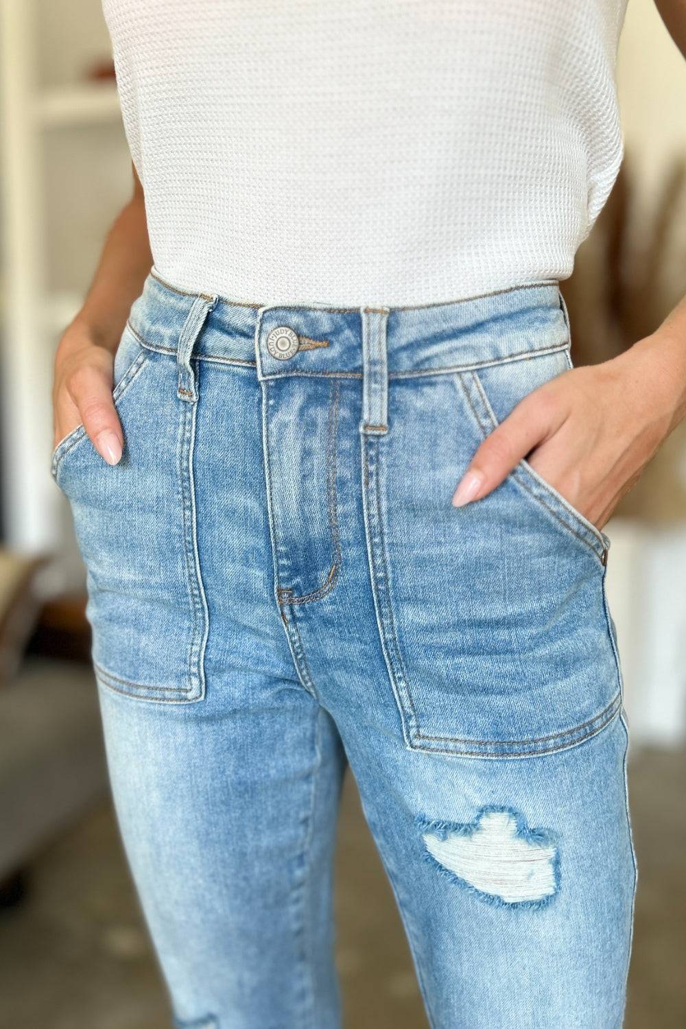 a woman wearing a white top and blue jeans