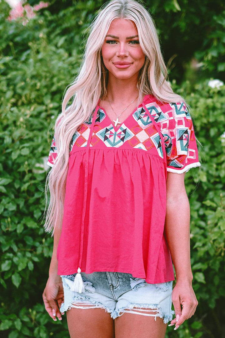 a woman wearing a pink top and denim shorts